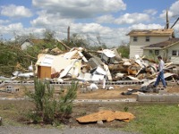 Meteorlogist-in-Charge of the NWS Huntsville office, Mike Coyne inspects severe damage to this home at the corner of Jackson and Broad Streets near downtown Albertville. The house was removed from the foundation and completely demolished. Another small house adjacent (but not pictured) suffered similar damage ~ 503 kb